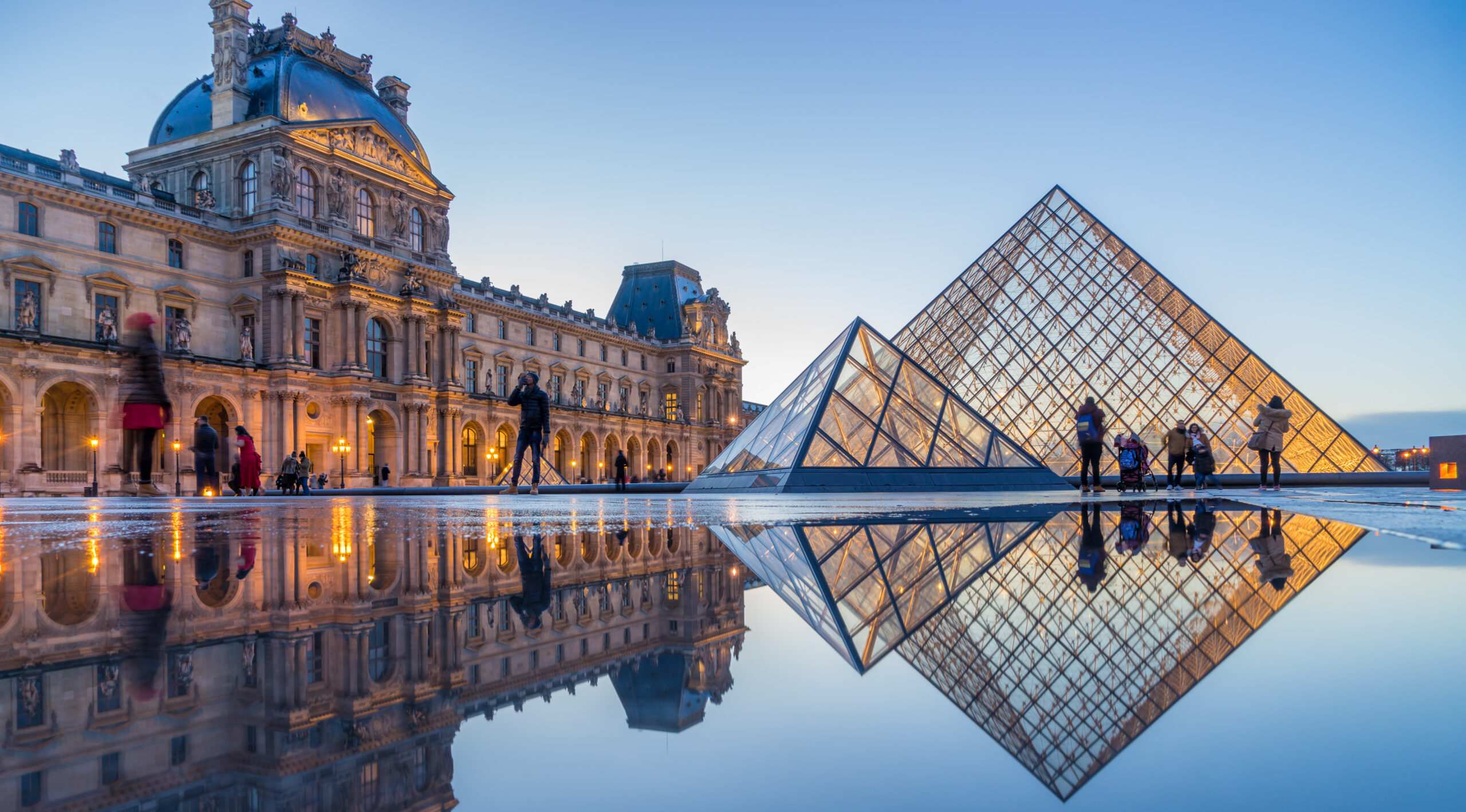 PARIS, FRANCE - DECEMBER 08, 2017: View of famous Louvre Museum with Louvre Pyramid at evening. Louvre Museum is one of the largest and most visited museums worldwide